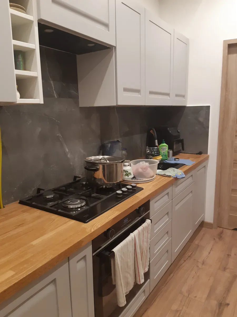 Wykończona kuchnia w stylu skandynawskim z szarymi szafkami i drewnianym blatem — Śródmieście Wrocław