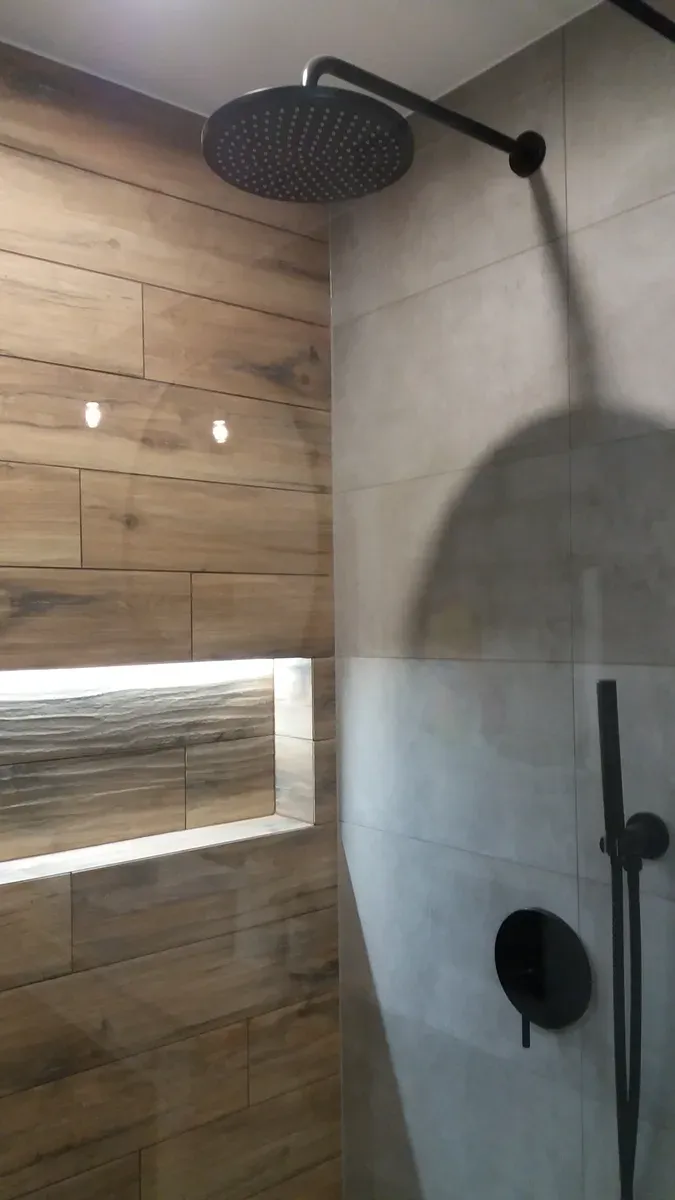 Strefa prysznica walk-in — czarna deszczownica i podświetlana wnęka