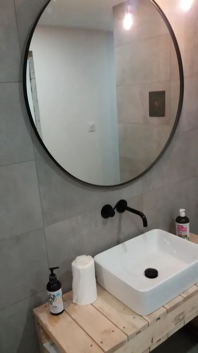 Strefa WC — podwieszana miska z czarnym przyciskiem spłukującym