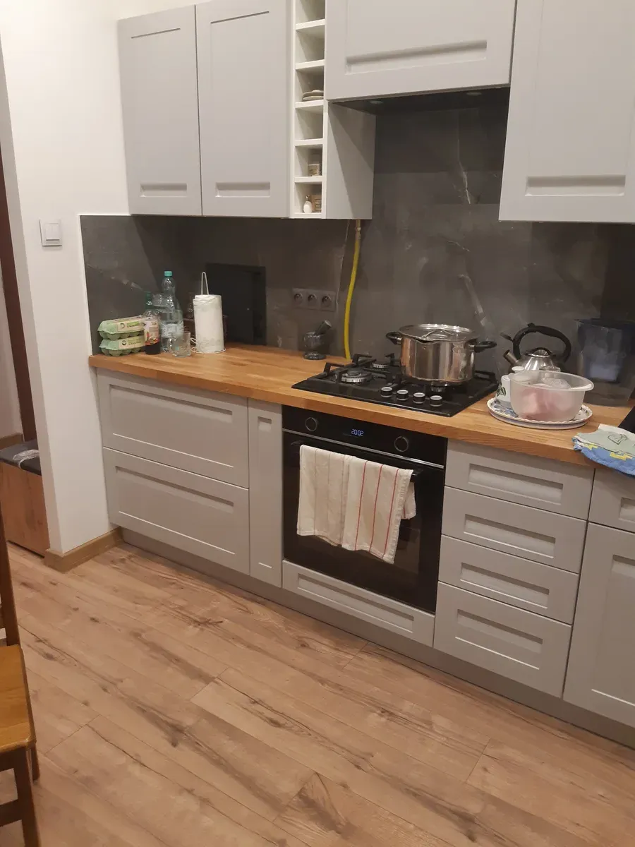 Kuchnia — widok na strefę zmywania z czarnym zlewozmywakiem